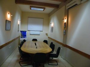 布琼布拉Botanika Hotel的一间会议室,配有木桌和椅子