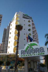 贝尼多姆Riviera Beachotel - Adults Recommended的一座带酒店标志和棕榈树的建筑
