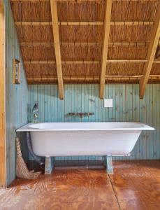 Sunrise-on-SeaDriftwood Treehouse的一间设有木制天花板的客房内的白色浴缸