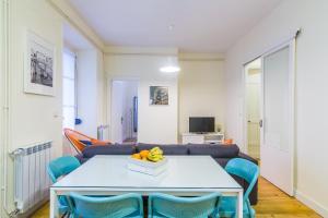 圣塞瓦斯蒂安Apartamento Urumea的客厅配有白色桌子和蓝色椅子