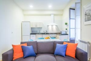 圣塞瓦斯蒂安Apartamento Urumea的客厅配有带橙色和蓝色枕头的沙发