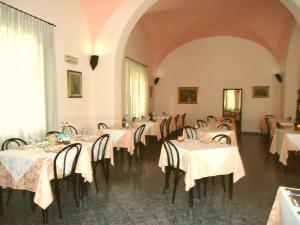 卡夏纳泰尔梅罗马阿尔伯格酒店的用餐室配有带白色桌布的桌子