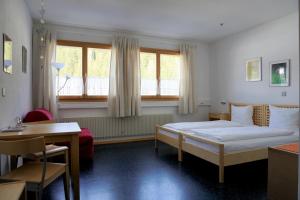 达沃斯志摩-达沃斯旅馆的卧室配有床、桌子和窗户。