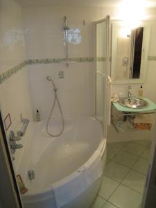 伊沃托瓦切斯勒马尼尔酒店的白色的浴室设有浴缸和水槽。