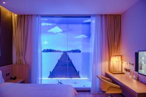 湛江IU酒店·湛江海滨大道鑫海名城店的一间卧室设有一张床和一个美景窗户。