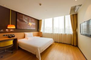 重庆IU酒店·重庆龙头寺火车北站店的酒店客房配有一张床、一张书桌和一台电视。
