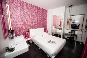 马德里金狮精品酒店的卧室配有白色的床和红砖墙