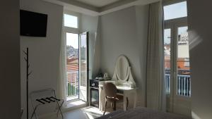 里斯本阿露比雅格兰德盘沙住宅酒店的一间卧室配有一张床、一张书桌和一面镜子