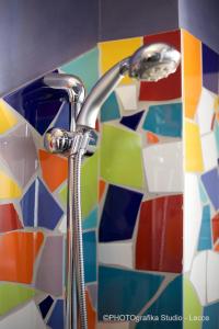 托雷拉皮罗Hotel Intervallo的浴室水槽和淋浴头位于马赛克瓷砖墙上。