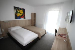 Marchegg马尔歇格伯恩斯坦旅馆的一间卧室设有两张床、一台电视和一扇窗户。