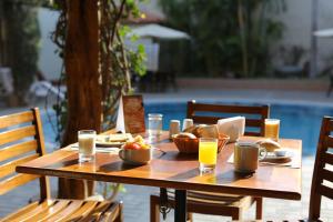 纳斯卡纳斯卡标准卡萨安迪娜酒店的一张带食物和橙汁的木桌