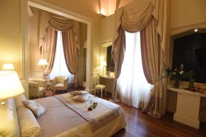 莱切圣基娅拉套房酒店的酒店客房设有一张大床和两个窗户。