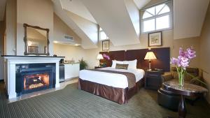 丹纳岬达纳波因特海滨贝斯特韦斯特酒店的一间卧室配有一张床和一个壁炉