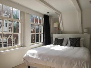 阿姆斯特丹九街住宿加早餐旅馆的一间白色卧室,配有床和2个窗户