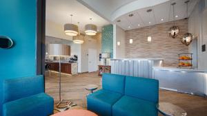 乔普林西部精选绿洲酒店及套房的一间带蓝色椅子的客厅和一间厨房