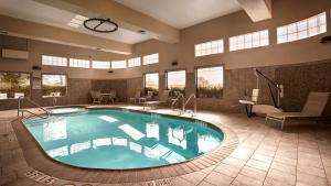 圣安东尼奥莱克兰贝斯特韦斯特PLUS套房酒店的大型客房的大型游泳池,配有桌椅