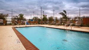 肯纳新奥尔良机场贝斯特韦斯特优质酒店的一个带椅子和围栏的大型游泳池