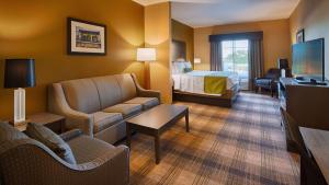 肯纳新奥尔良机场贝斯特韦斯特优质酒店的酒店客房设有床和客厅。