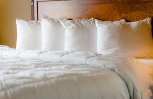 Wildwood怀尔德伍德酒店的一张带白色枕头和床头板的床