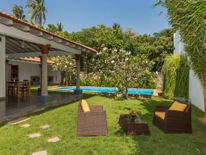 蓬蒂切里Kadal The Beach House的一个带两把椅子的庭院和一个游泳池