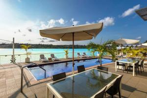 维拉港海湾上的尚蒂伊酒店的一个带桌椅和遮阳伞的游泳池