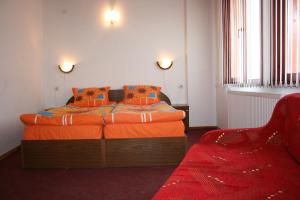 班斯科阿塞瓦屋家庭酒店的一间卧室配有带橙色床单和椅子的床