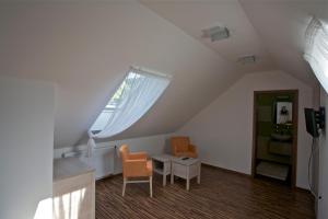 Marianka普特尼基米伦旅馆的阁楼间设有两把椅子、一张桌子和一扇窗户。