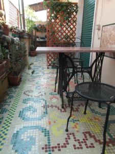 罗马阿比塔兹纳皮吉纳托住宿加早餐酒店的马赛克地板上带桌椅的天井。