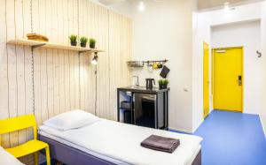 塔尔图赫克托设计旅舍的小房间,设有床和黄色门