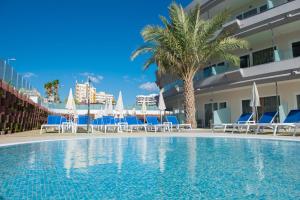 英格兰海滩HL Suitehotel Playa del Inglés - Adults Only的游泳池,带椅子和遮阳伞