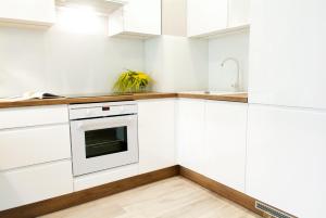 格鲁德柴兹Apartament 4 You的厨房配有白色橱柜和水槽