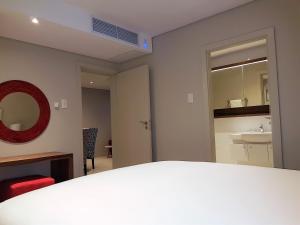 巴利托Zimbali Suites 301的客房设有带水槽和镜子的浴室