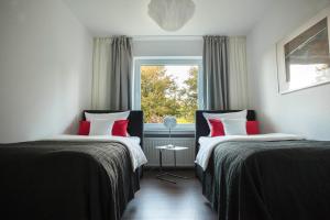 不莱梅Luxussuite mit Steinway-Flügel的带窗户的客房内的两张床
