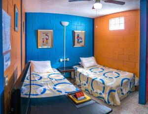 危地马拉Hostal Guatefriends的蓝色墙壁客房的两张床