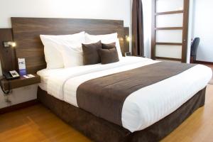 马尼萨莱斯卡雷特罗酒店的卧室配有一张带白色床单和枕头的大床。