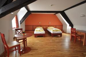 梅尔斯堡JUFA Hotel Meersburg am Bodensee的阁楼间设有两张床和一张桌子及椅子