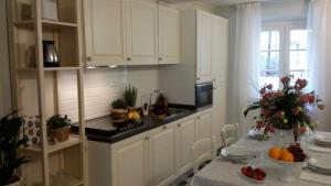 卢卡Luxury apartment Suite La Fontana的厨房配有白色橱柜和水果桌