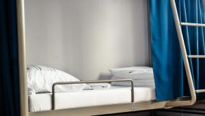 普里什蒂纳ODA Hostel的配有蓝色窗帘的客房内的双层床