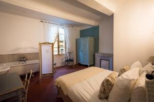 屈屈龙Les Chambres De Charlotte的一间卧室配有一张床、一个水槽和一个壁炉