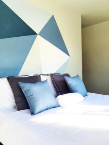 清迈八月旅舍的一张带蓝色枕头的床和一个几何床头板
