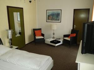 托特莫斯Hotel-Pension Waldeck的酒店客房带一张床、椅子和电视