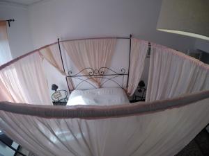 热那亚B&B Al Fronte del Porto的卧室配有带白色床单的天蓬床