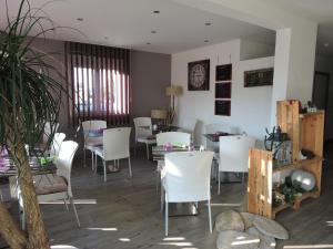 福龙河畔拉罗什Hotel le Foron的一间配备有白色椅子和桌子的用餐室