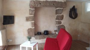 BégardGite La Chouette的客厅设有红色椅子和石墙