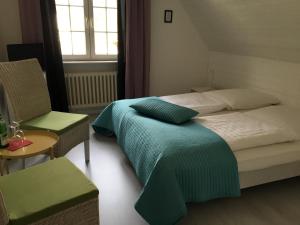 霍瓦赫特Das Ostseehotel的一间卧室设有两张床、一把椅子和一个窗户。