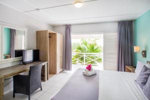 威廉斯塔德库拉索比尼盂兰盆海滨度假胜地的客房设有一张床、一张书桌和电视
