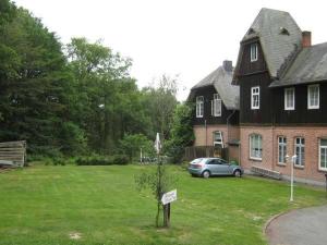 Niederhaverbeck埃克霍夫乡村酒店的把车停在院子的房子