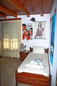 普里诺斯Katoikia me ta Pitharia的卧室配有一张床和墙上的海报