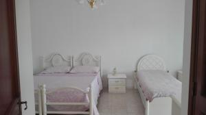 切萨雷奥港Villa Bouganville的白色卧室配有两张床和椅子