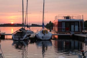 Kollund ØsterskovHausboot FJORDBLIK的一组船在日落时分停靠在码头